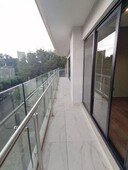 departamento moderno con balcón y vista arbolada